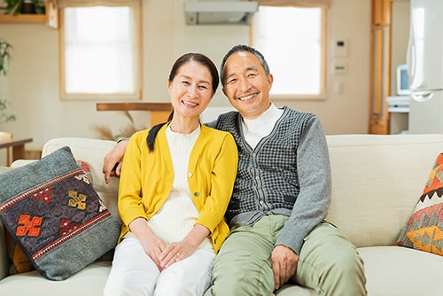 肩を寄せ笑顔の60代夫婦イメージ
